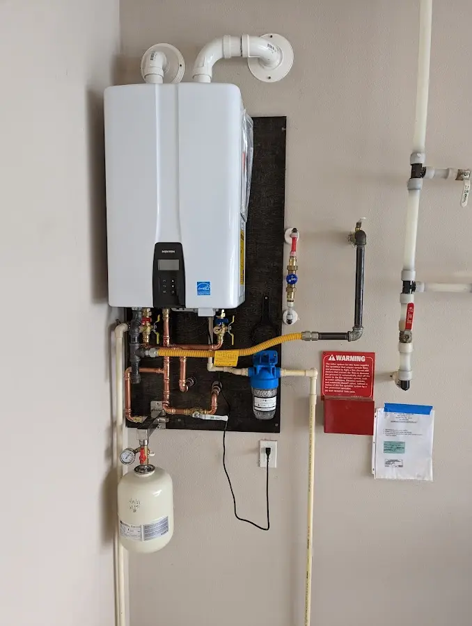 Professional plumber installing copper piping in a Mather home